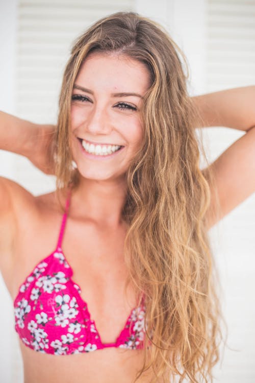 Close-up Photo of Smiling Woman in Pink and White Floral Bikini Top