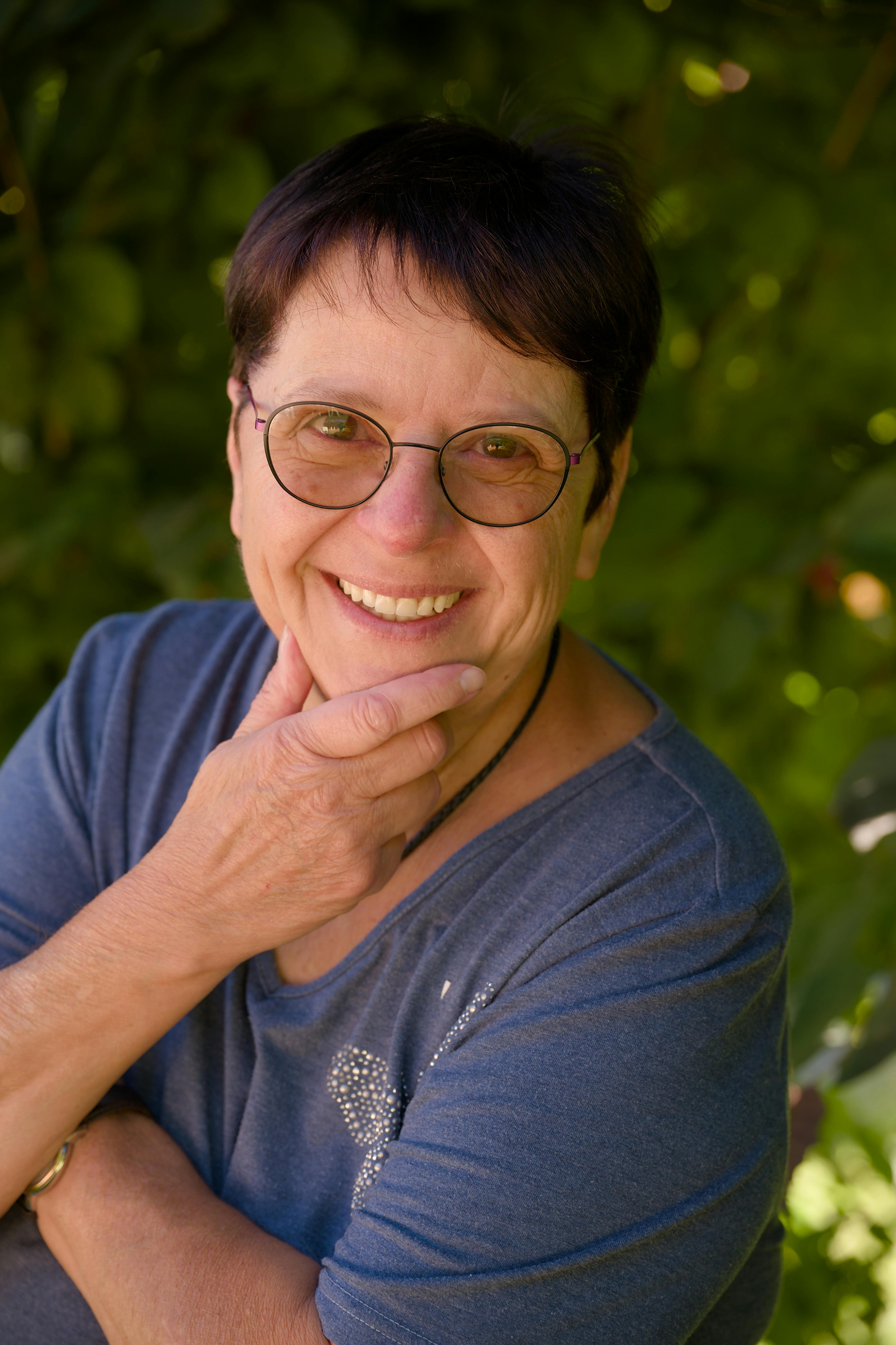 Portrait of a smiling woman outdoors in Le Locle, Switzerland, during summer.