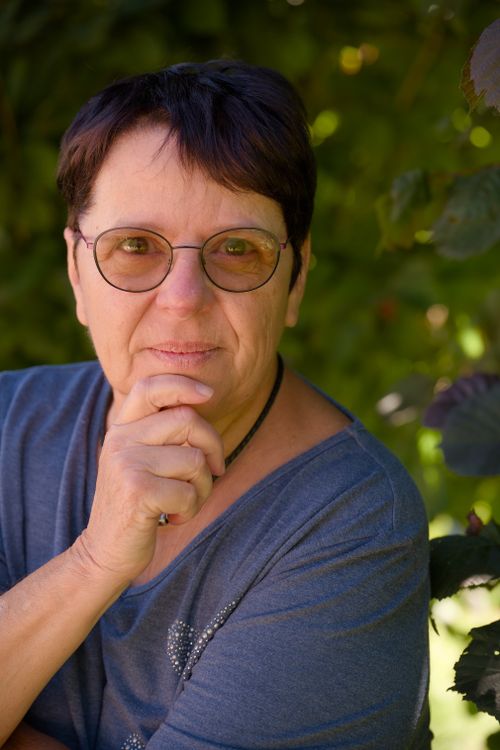 Free Senior woman with glasses in contemplative pose outdoors. Stock Photo