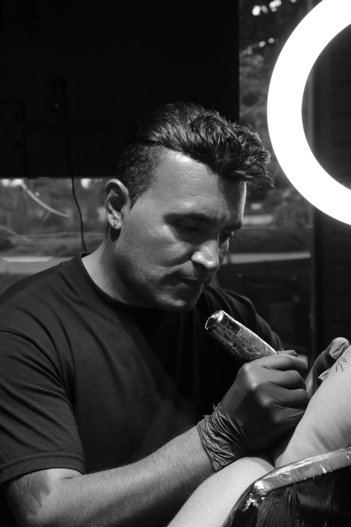 Lead tattoo artist Theo Marchetti holding a machine