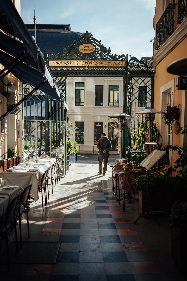 An Alley With Tables Outside Of Restaurants In A Town 