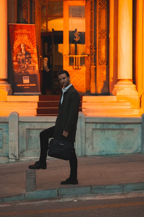 Elegant Man Holding a Briefcase Standing on the Sidewalk 