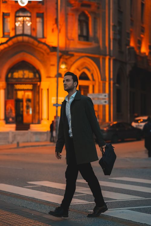 Free Stylish man in coat and suit walking across crosswalk in Ankara city evening. Stock Photo
