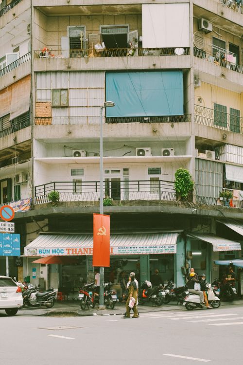 Free A vibrant street scene in a Vietnamese city with motorbikes and pedestrians. Stock Photo