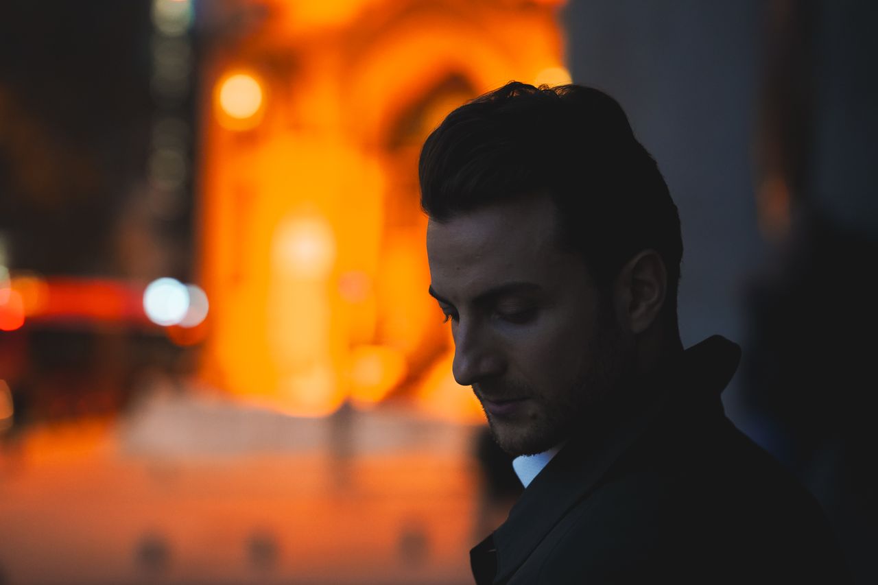 a contemplative man captured at sunset against an urban backdrop in an