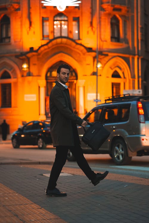 Man in Suit Walking with Bag on Street