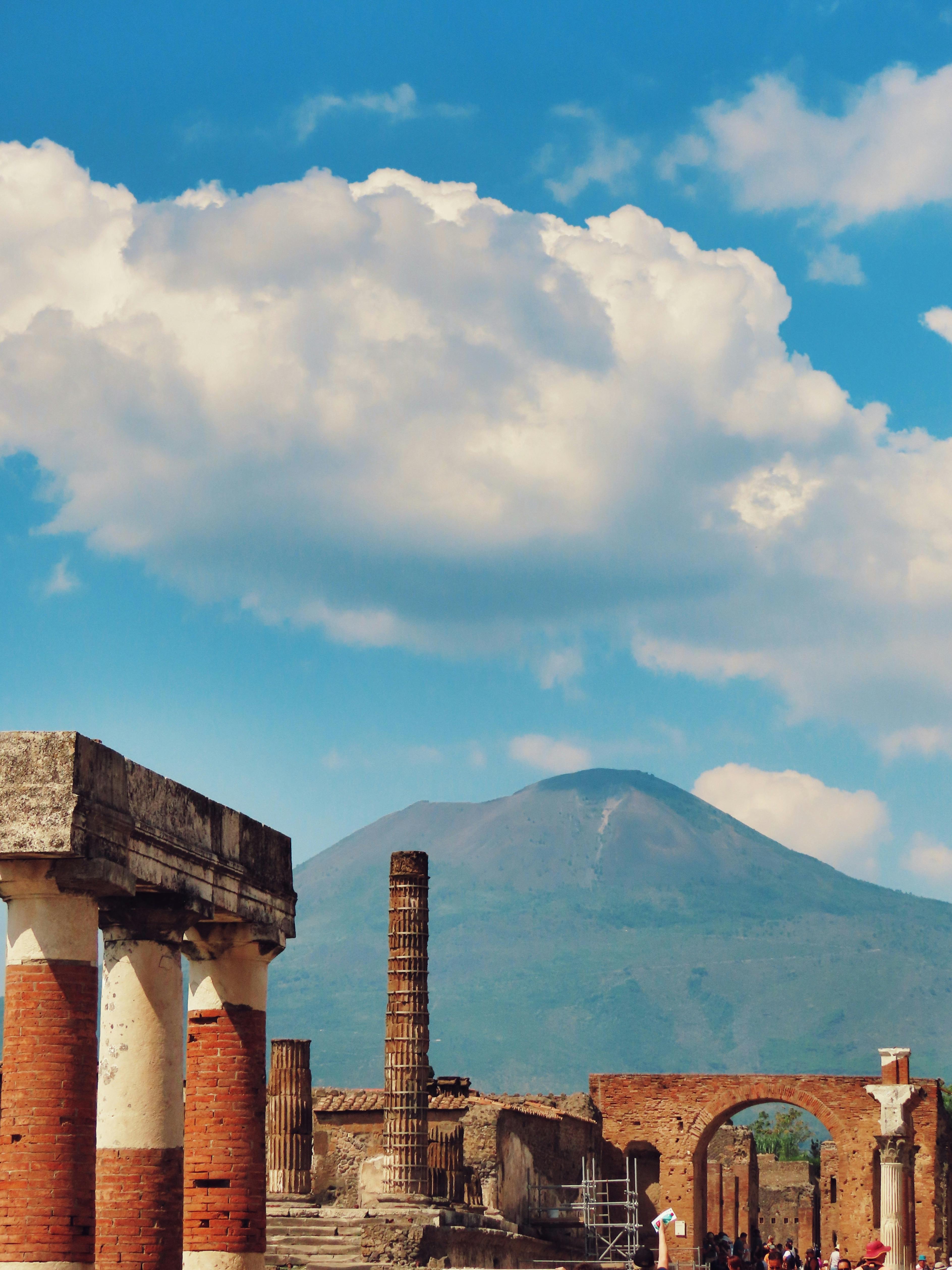 Explore the ancient ruins of Pompeii with Mount Vesuvius in the background.