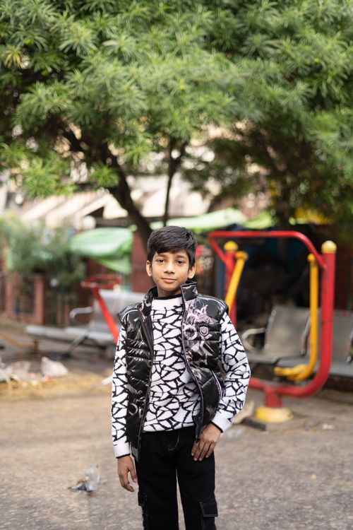 Free A young boy poses outdoors in casual clothing, showcasing urban style. Stock Photo
