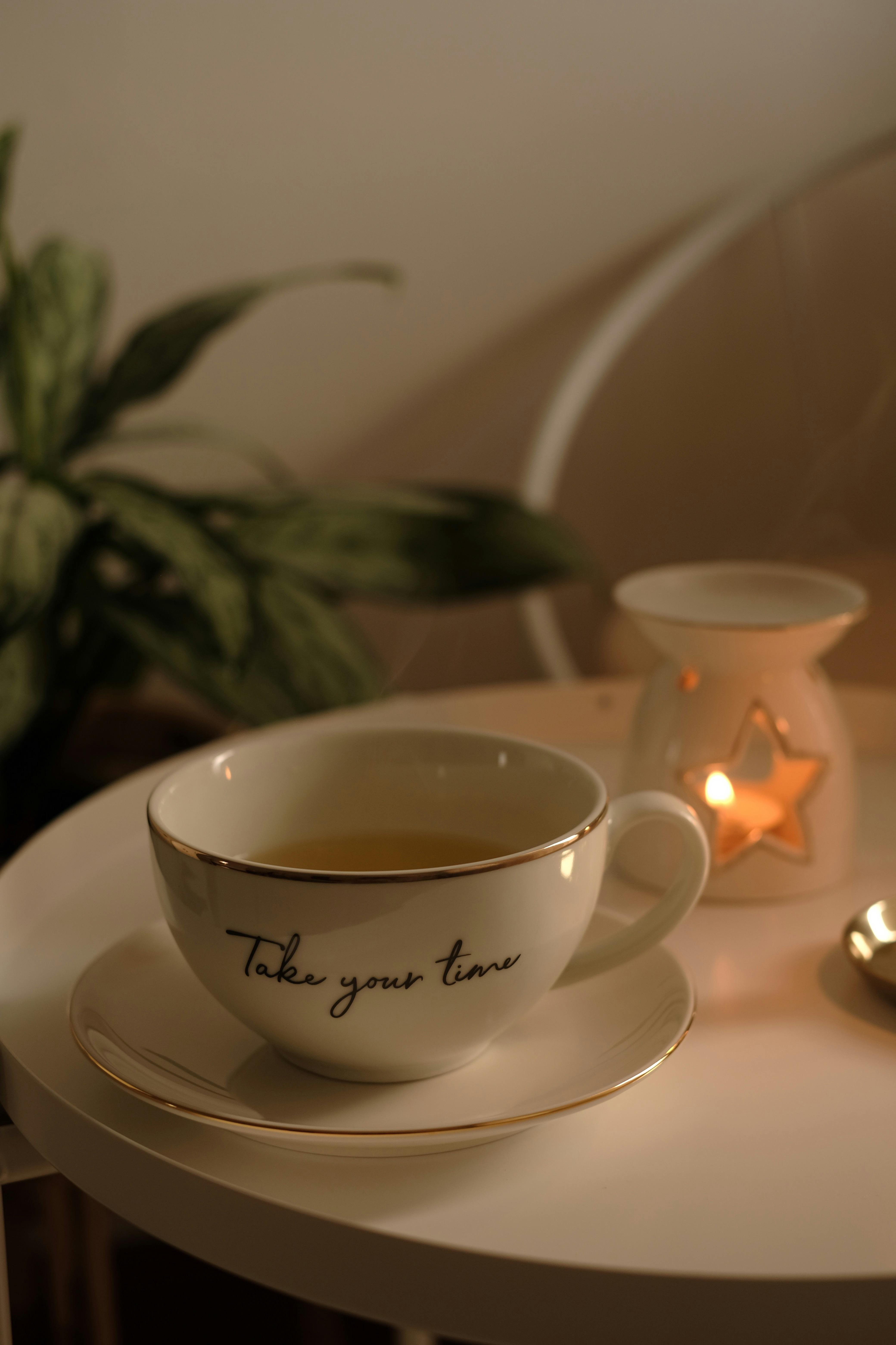 A serene setup with a cup of tea and candlelight on a cozy table, perfect for relaxation.