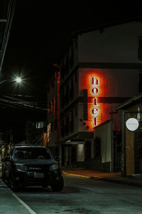 Free Moody street view in Mérida, Venezuela with neon hotel sign illuminating the dark. Stock Photo