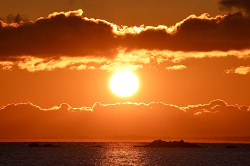 View of Bright Sunlight and Orange Sky at Sunset over a Sea 
