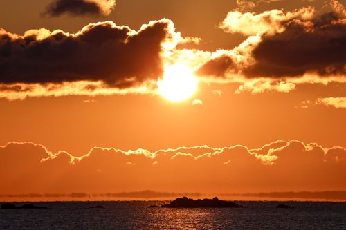 Free Stunning sunset with dramatic clouds and ocean reflection, perfect for serene and peaceful scenes. Stock Photo