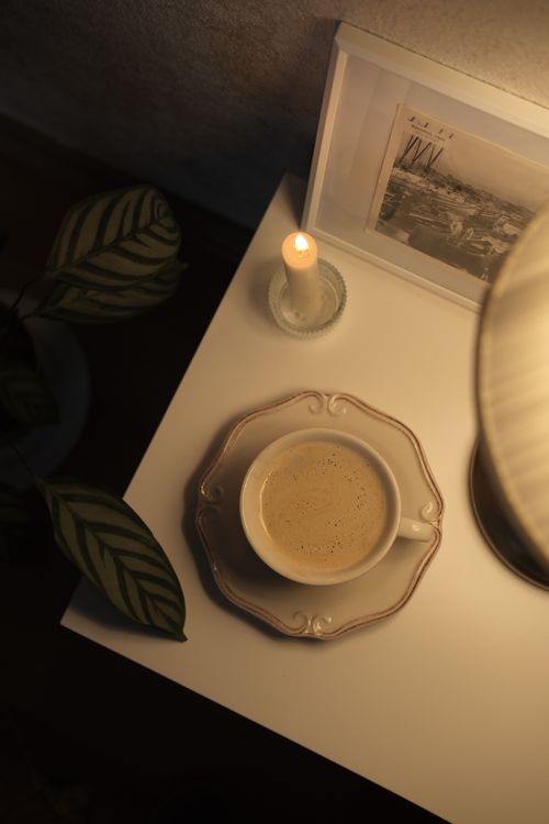 Free A warm and cozy scene featuring a cup of coffee with a candlelight ambiance and decorative elements. Stock Photo