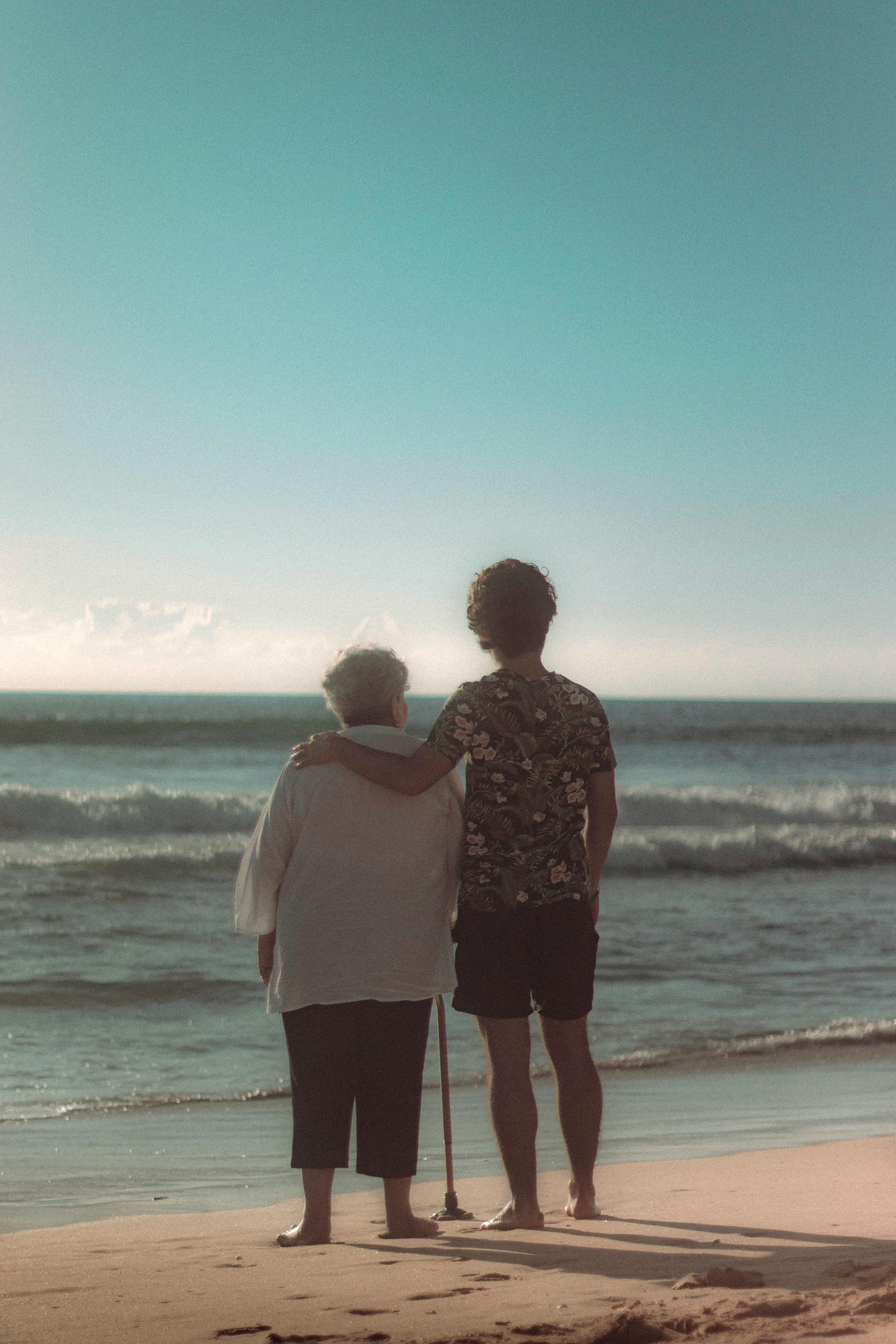 A touching moment as a grandmother and child embrace while looking at the ocean on a sunny day in Mazatlán, México.