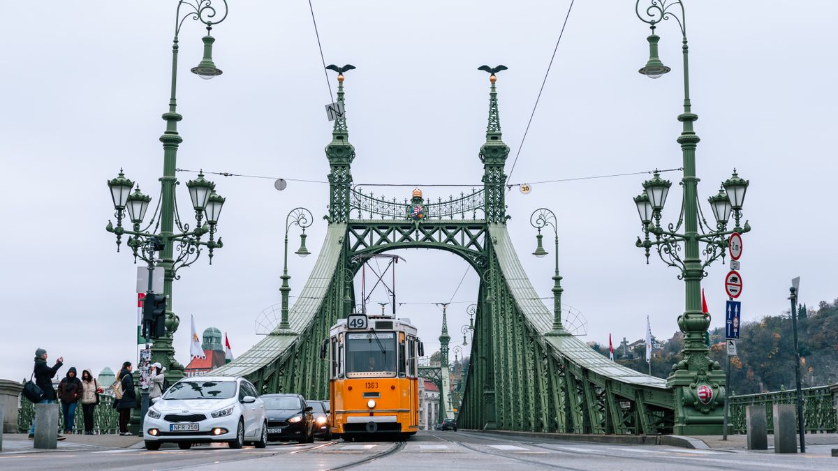 Tram crossing Liberty Bridge in Budapest capturing urban life and iconic architecture.