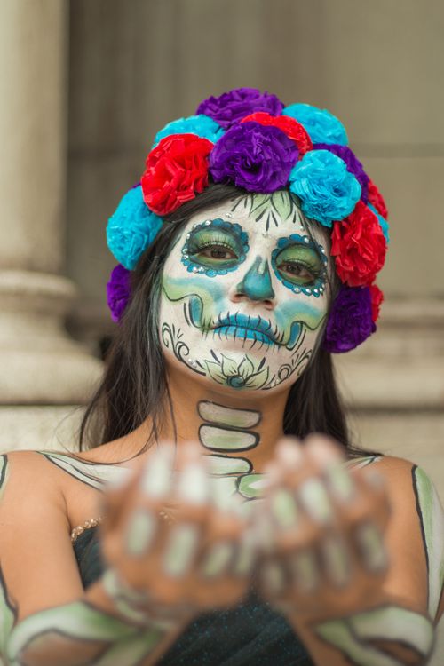 Free Colorful portrait of a woman in Day of the Dead makeup with floral headdress. Stock Photo