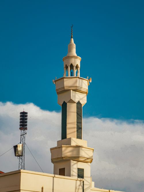 Free Close-up of a tall, elegant white minaret against a clear blue sky, showcasing Islamic architecture. Stock Photo
