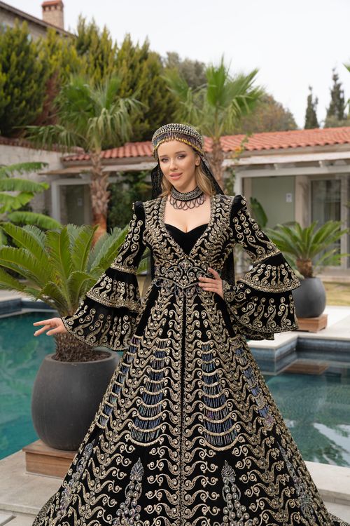 Free A woman in a luxurious embroidered dress poses beside a pool in İzmir, Türkiye. Stock Photo