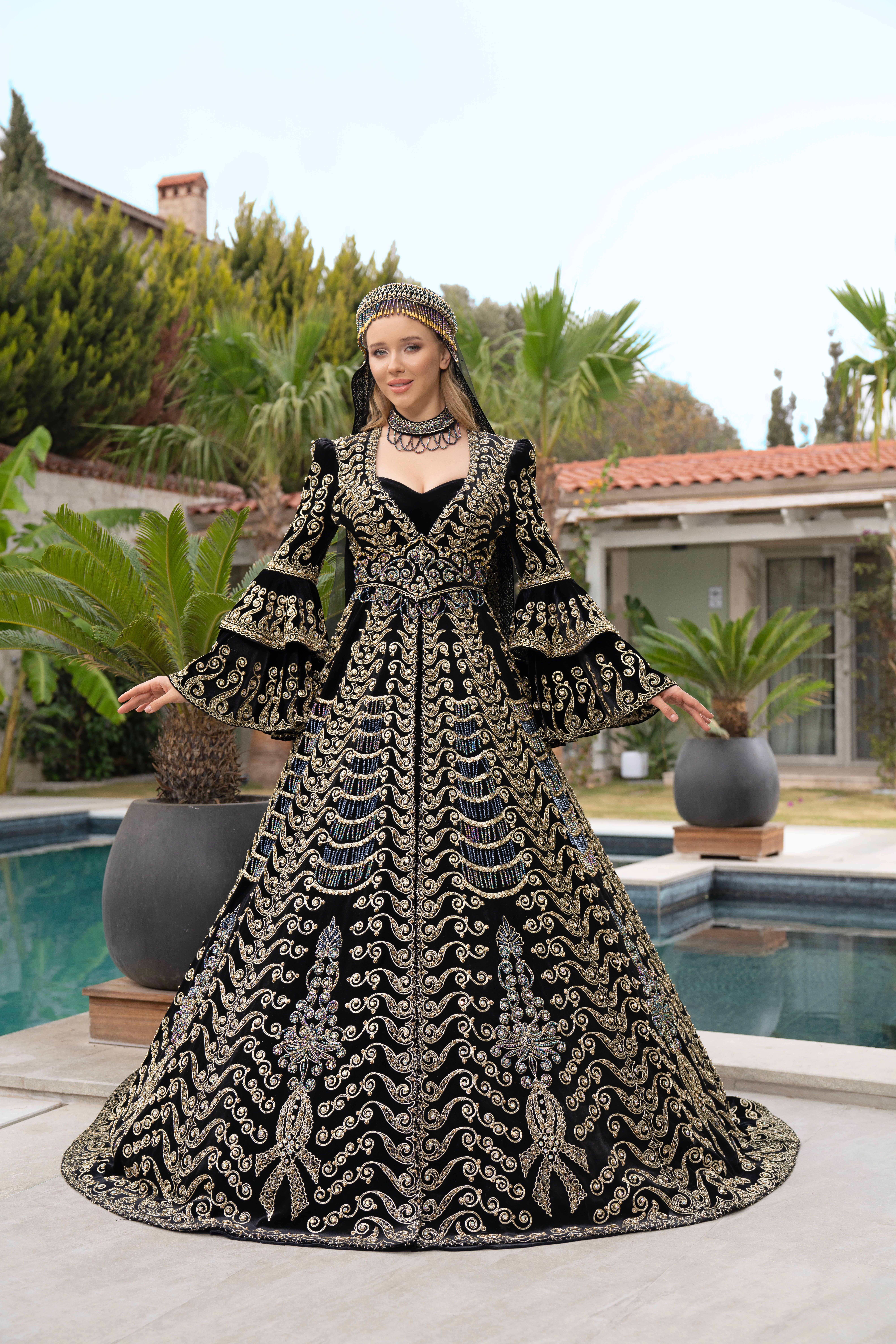 A beautiful woman in a lavish traditional gown poses by a poolside in İzmir, Türkiye.
