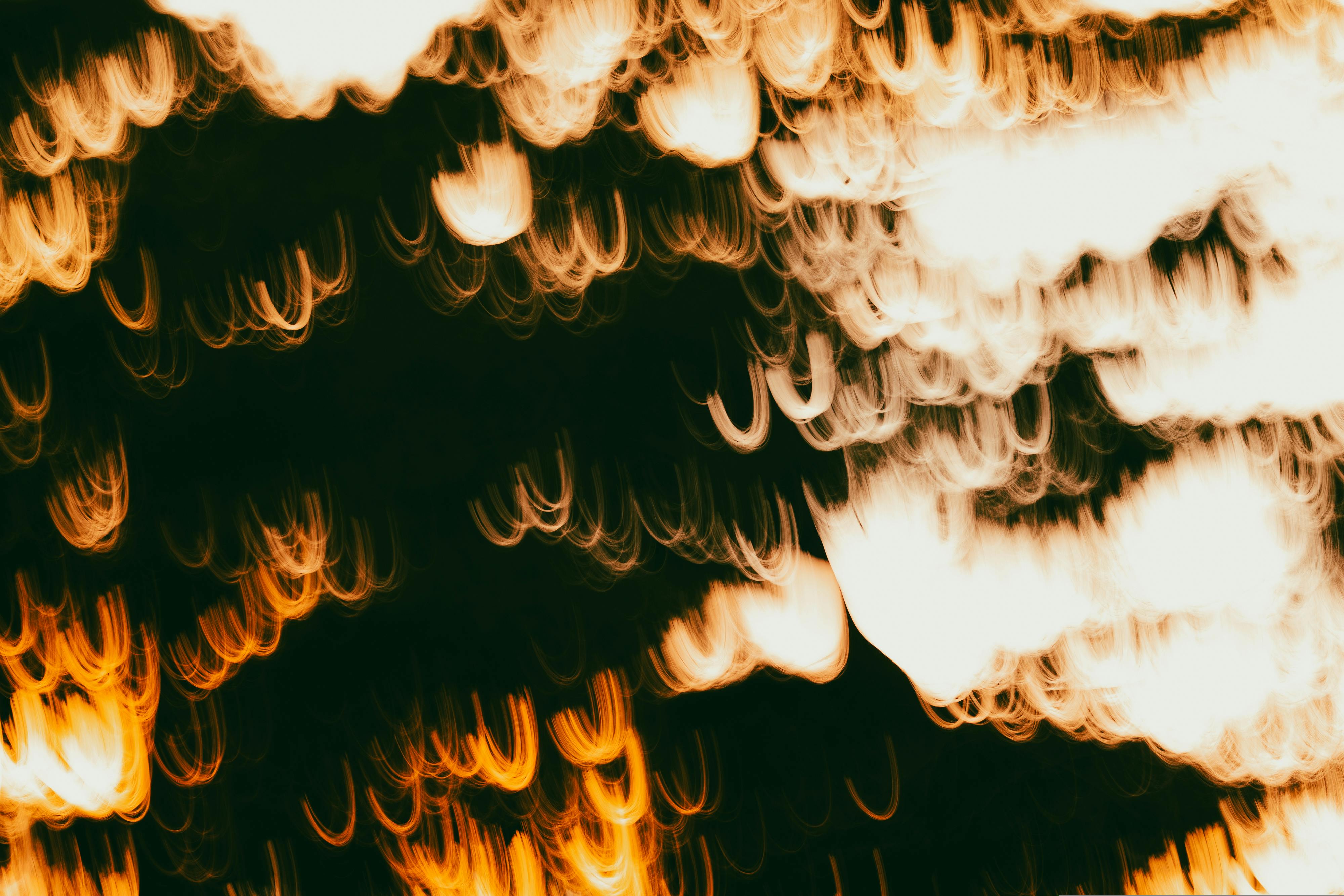 A creative abstract photo capturing warm and dark light trails against a dark backdrop.