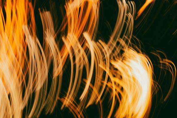 Amber light streaks on a dark field. Photo by terence b on Pexels