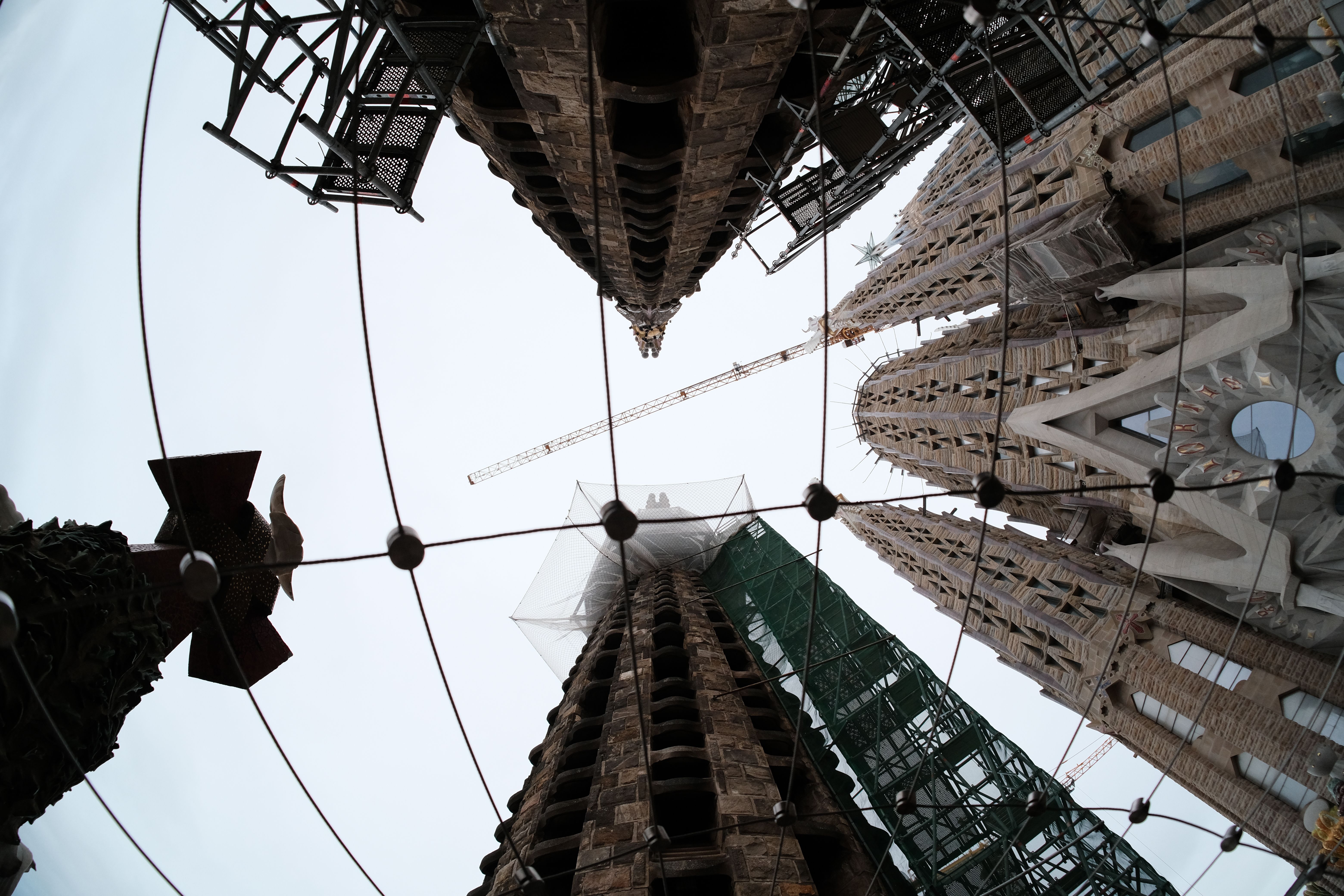 Vista de las torres de la Sagrada Família de Barcelona contra el cielo azul, con las grúas de construcción al fondo