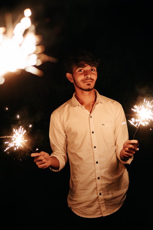 Portrait of a Man Holding Burning Sparklers