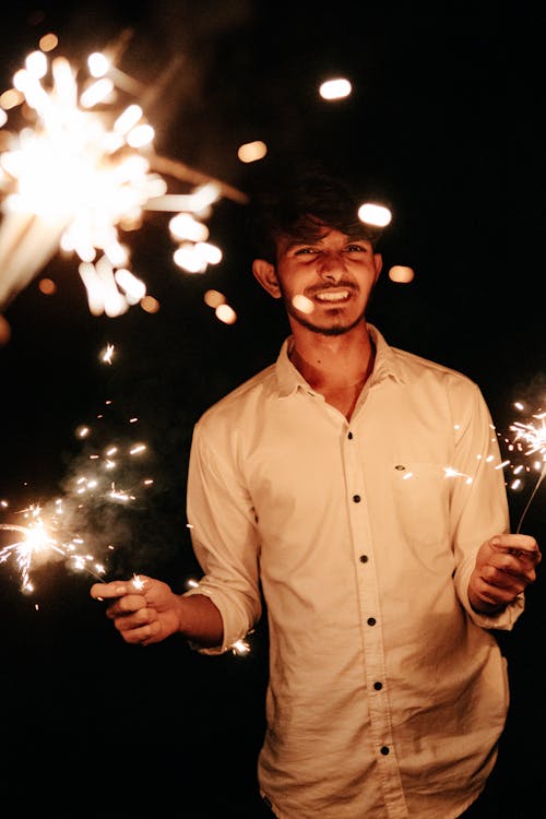 Young Man Holding Burning Sparklers