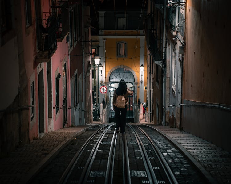 Woman Walking On Tracks At Night 