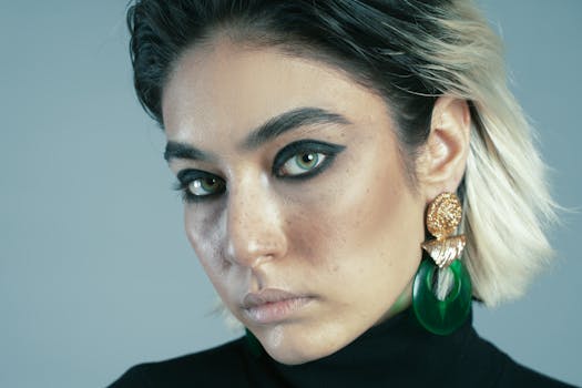 Close-up of an Iranian woman with green eyes, bold makeup, and statement jewelry.
