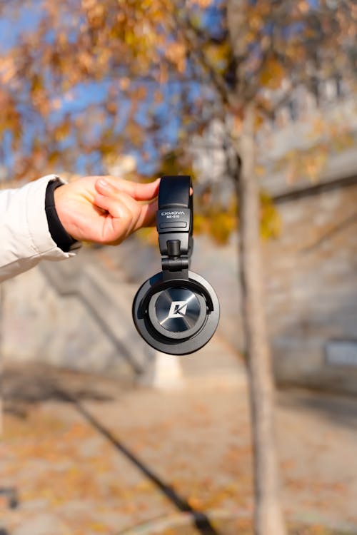 Hand Holding Wireless Headphones