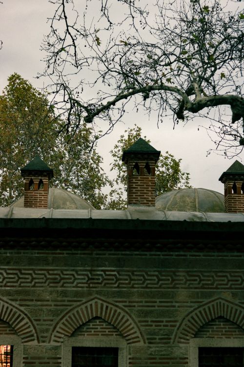 Free Vintage architectural building with domes and chimneys against a moody sky. Stock Photo