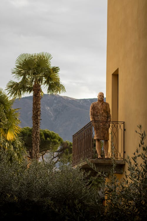 manikin on Swiss balcony with palm trees