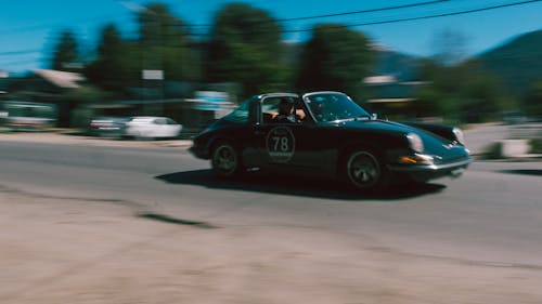 Blurred Motion of a Vintage Sports Car Driving on a Street 