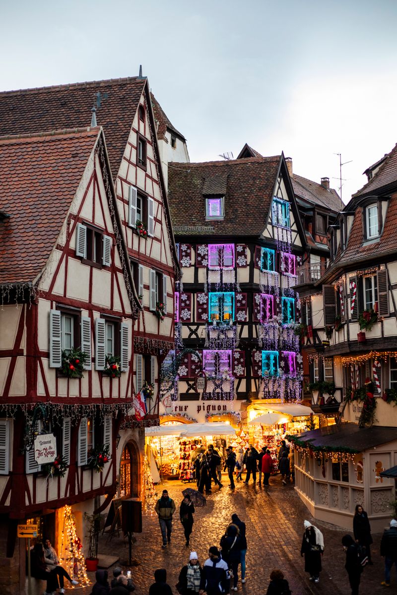 Piața de Crăciun din Colmar, Franța, cu case colorate și decorațiuni festive