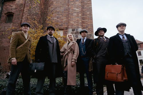 Woman in a Brown Coat Standing with a Group of Elegant Men 