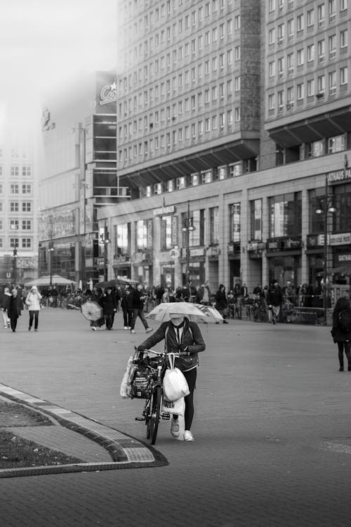 Black and White Photo of Pedestrians Walking on a Street in City 