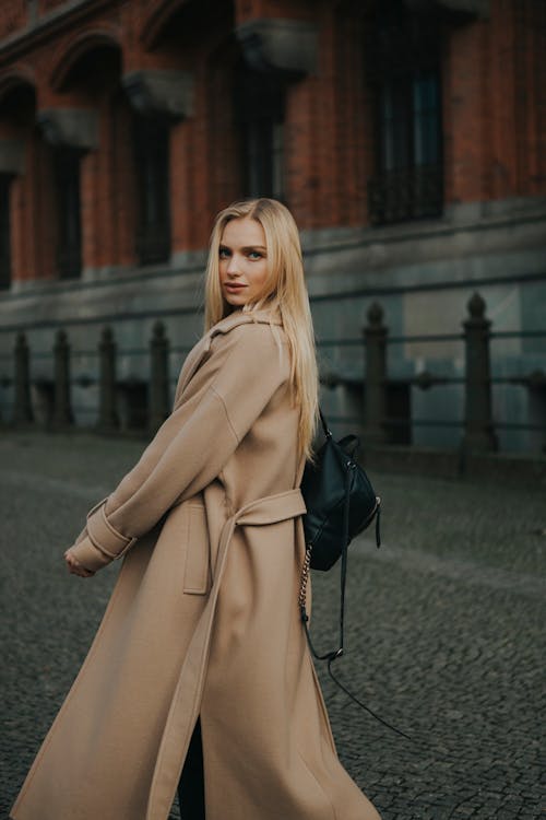 Fashionable Woman in a Brown Coat Walking on a Street in City 
