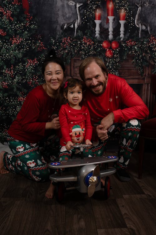 Family with a Child Posing in front of a Christmas Tree 