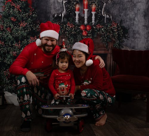 Family on Santa Hats beside Christmas Tree