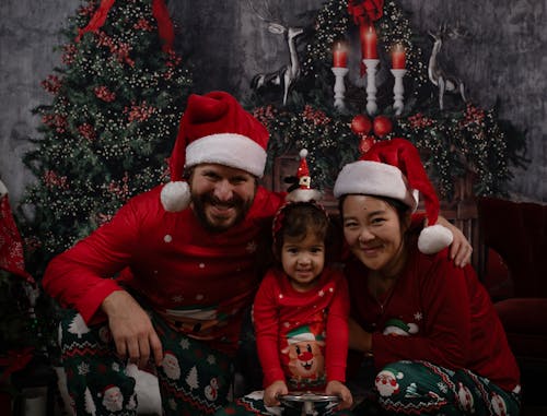 A Family in Matching Pajamas Posing among Christmas Decorations 