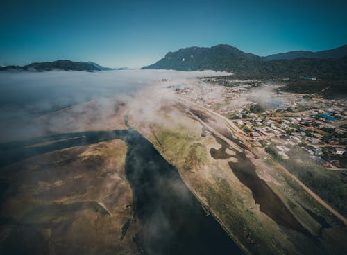 Aerial View of a Town in a Valley Covered with Fog Coming From the Bay
