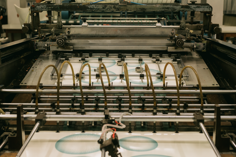 Close-up of an industrial printing press producing designs