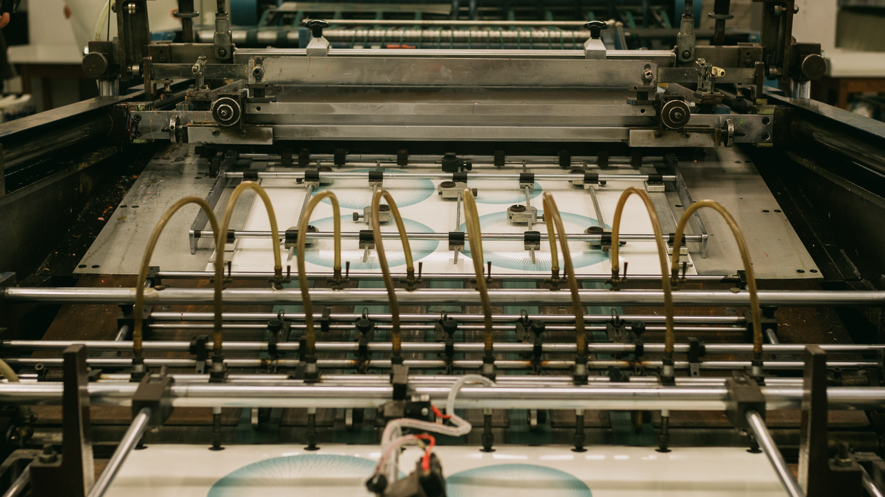 Close-up of an industrial printing press producing designs.