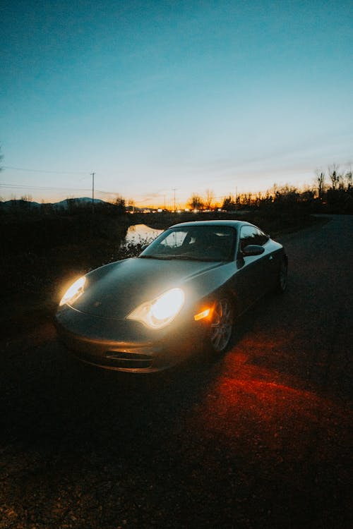 Sports Car on Road in Countryside at Sunset