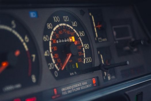 Close-up of a classic car dashboard highlighting the speedometer, odometer, and instrument panel.