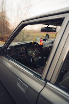 Close-up of a classic car interior seen through an open window, featuring retro design elements.