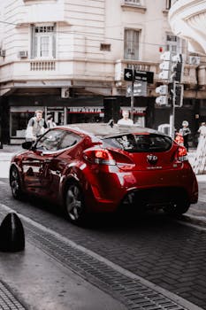 A modern red car driving through the streets of Buenos Aires, Argentina.