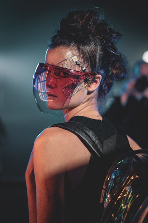Model with a Futuristic Face Decoration and Purple Gradient Visor Glasses