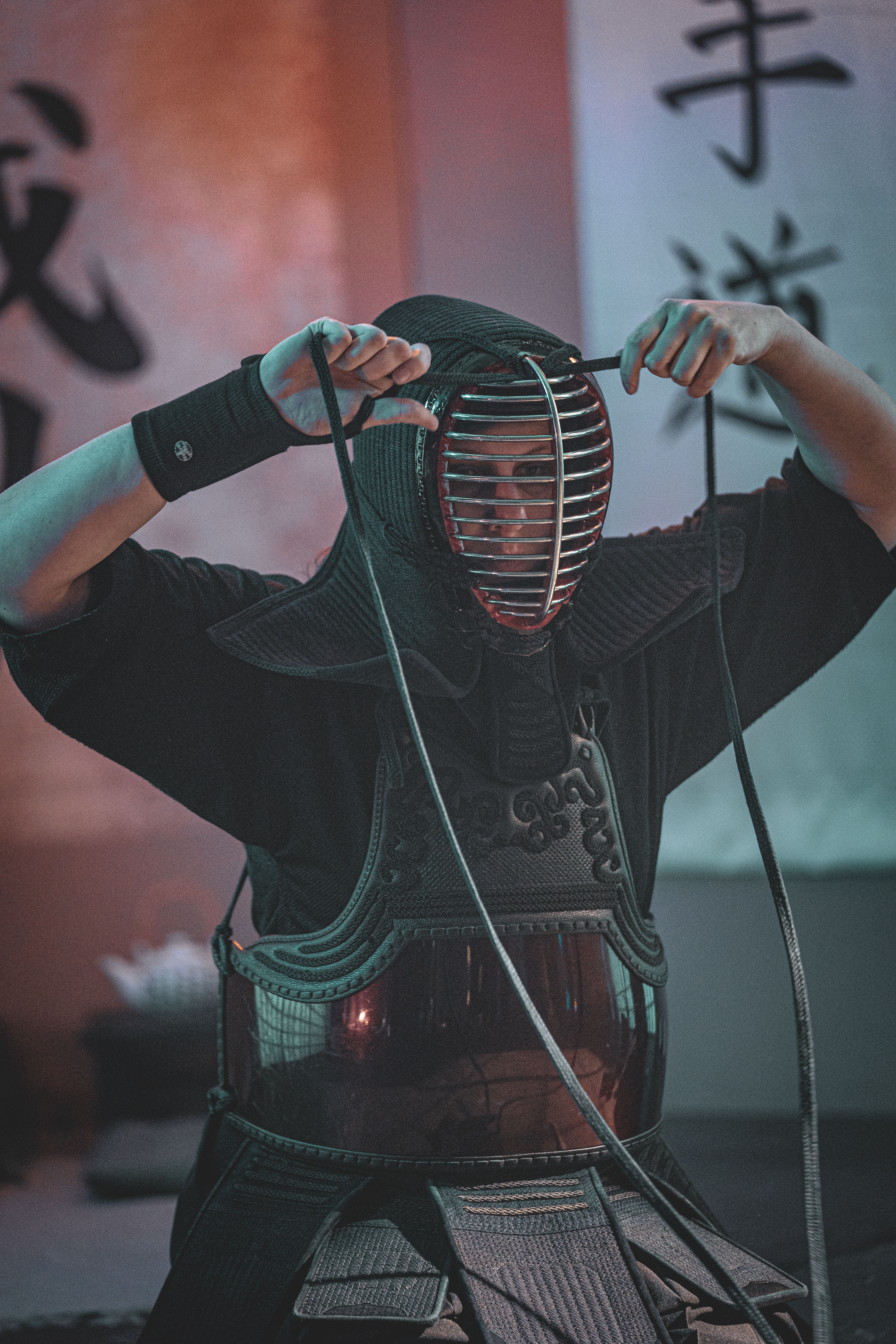 Martial artist practicing kendo indoors wearing traditional armor during a practice session.